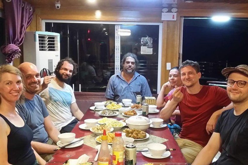Eine Gruppe von Personen sitzt an einem Tisch mit verschiedenen Speisen und Getränken. 5