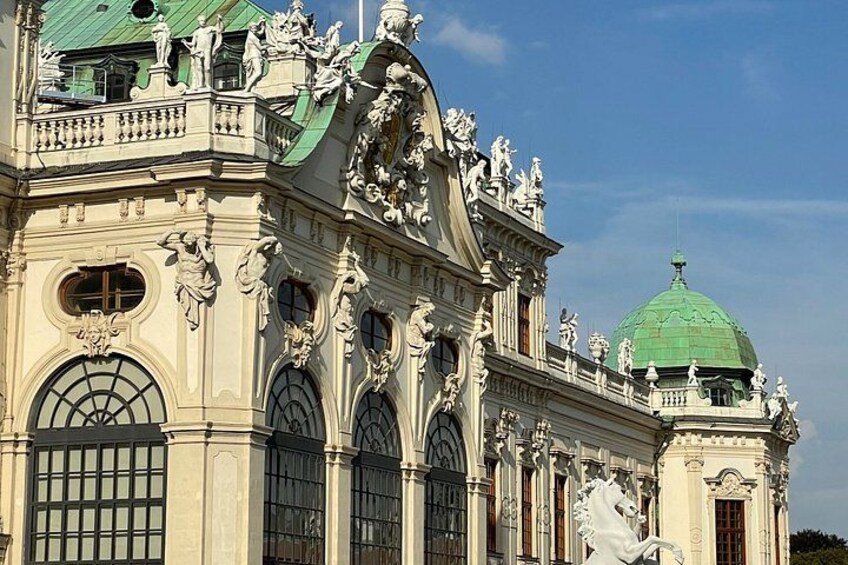 A classical building with ornate sculptures, a green dome, and large arched windows. 3