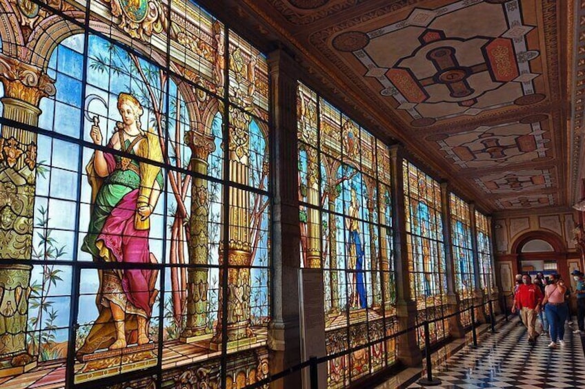 A hallway with stained glass windows and a checkered floor. 5