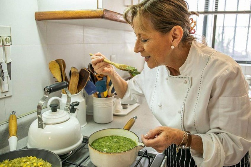 Una persona cocinando en una cocina con una olla en la hornilla, una tetera y varios utensilios. 3