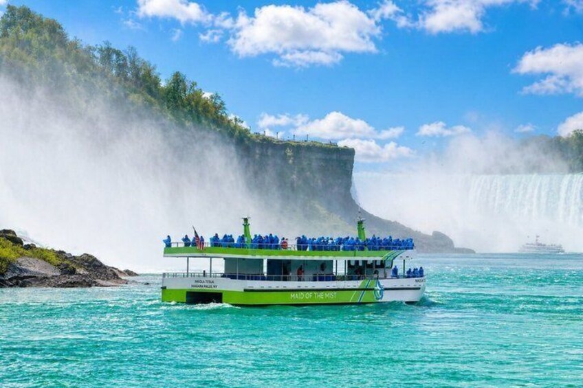 A boat named 'Boat of the Mist' with passengers, near a waterfall. 4