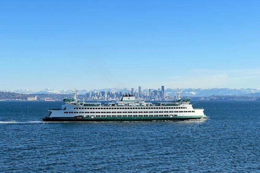 A large cruise ship on a body of water with a city skyline in the background. 2