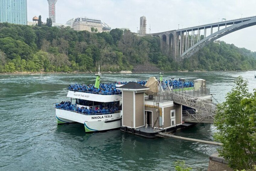A riverboat named 'Nikola Tesla' docked at a pier with a bridge in the background. 2