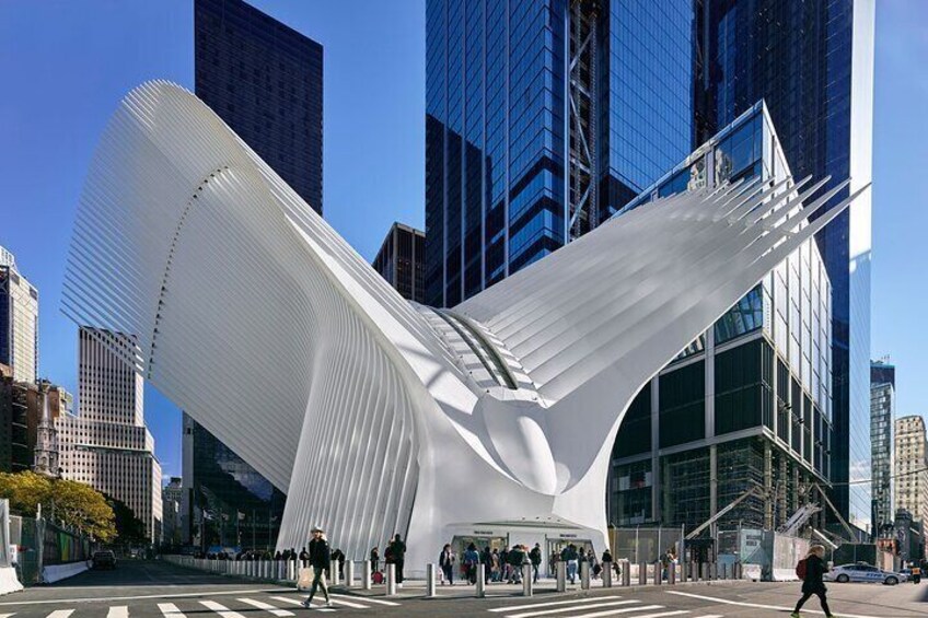 A modern white building with a curved roof, surrounded by tall skyscrapers. 4