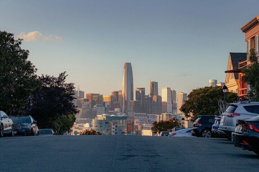 A cityscape with modern skyscrapers, parked cars, and residential buildings. 2