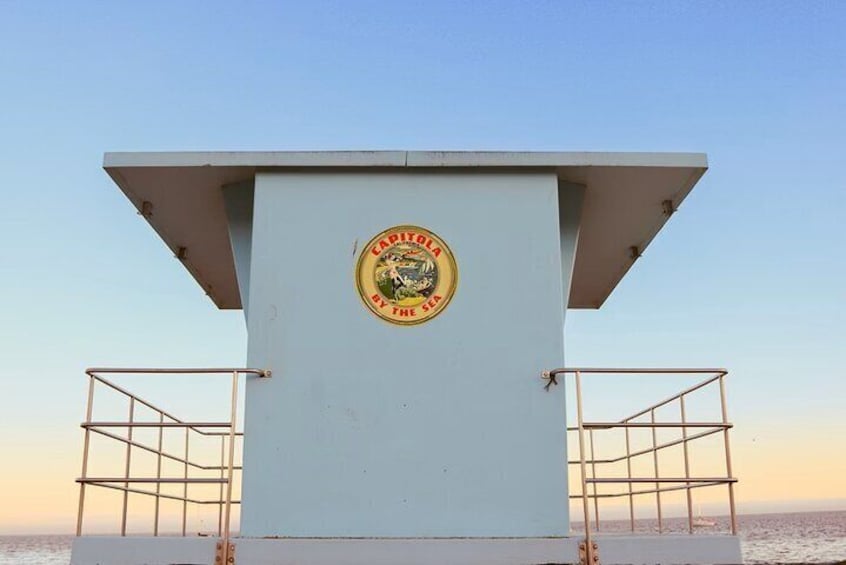 A lifeguard tower with a circular emblem on the front. 5