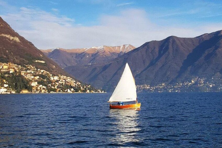 A sailboat on calm water with a mountainous landscape in the background. 3