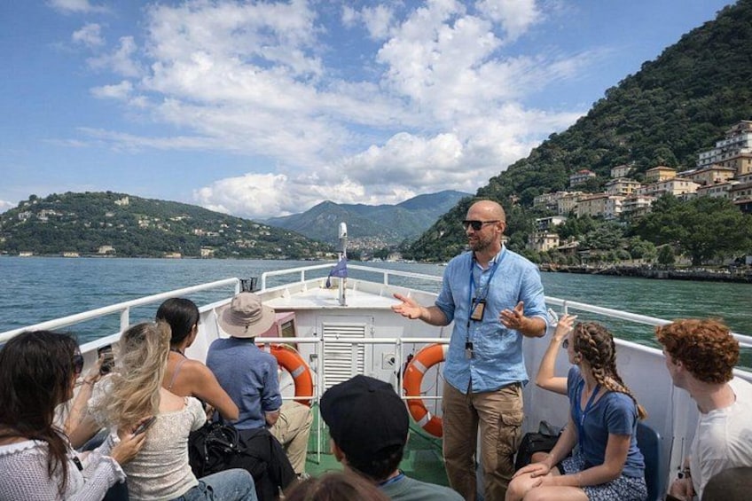 A boat with passengers and a guide, surrounded by water and hills. 5