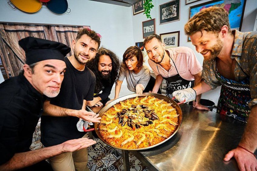 Un grupo de personas alrededor de una paellera, posiblemente un plato con mariscos. 4