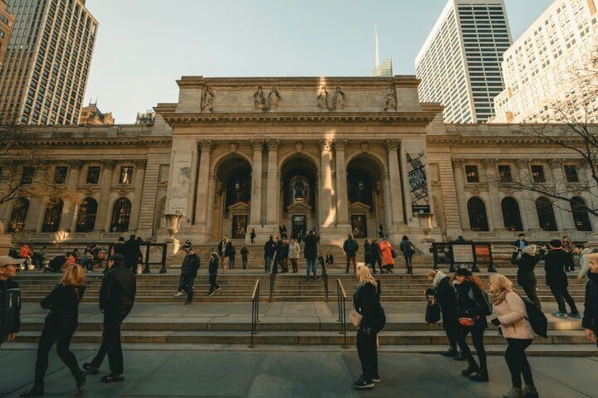 A large classical building with steps leading up to it, surrounded by modern high-rise buildings. 5