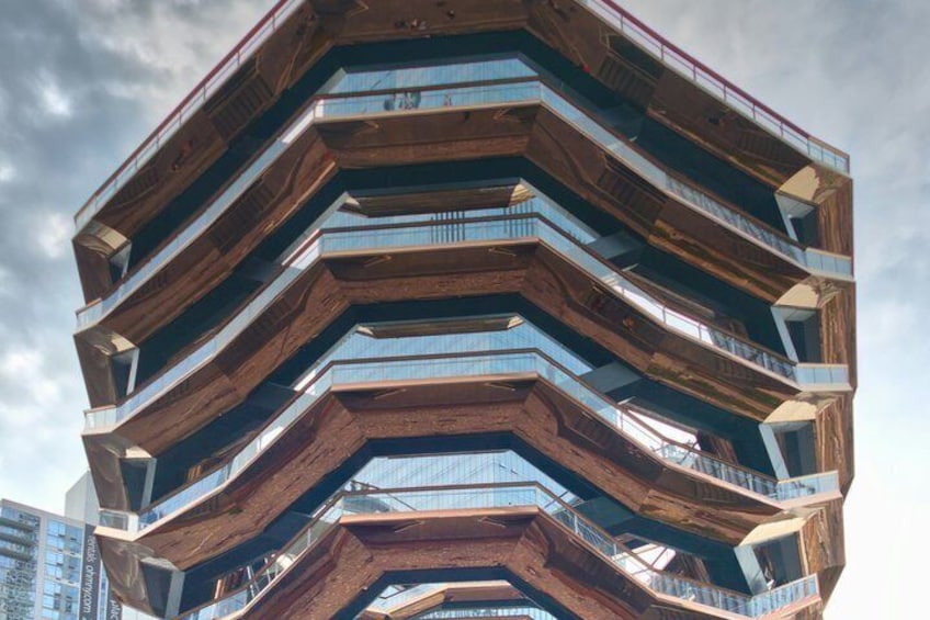 A modern architectural building with multiple balconies and a unique zigzag design. 2