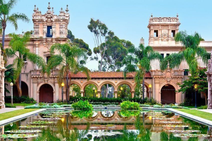 A historic building with ornate architecture, a central fountain, and lush greenery. 3