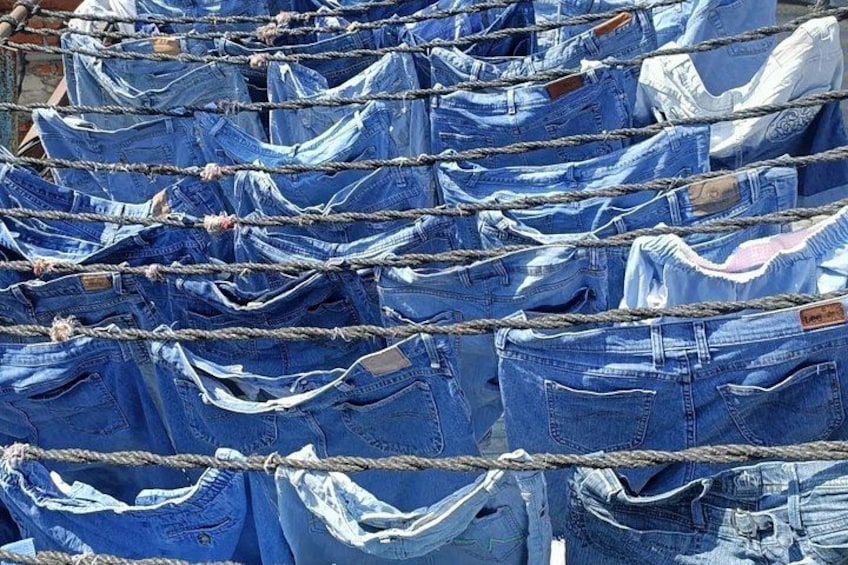 A collection of jeans hanging on ropes. 5