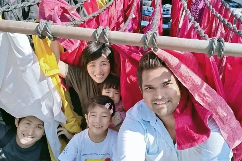 A group of people hanging from a rope structure with colorful fabrics. 4