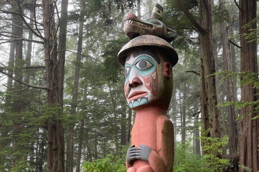A totem pole in a forest. 2