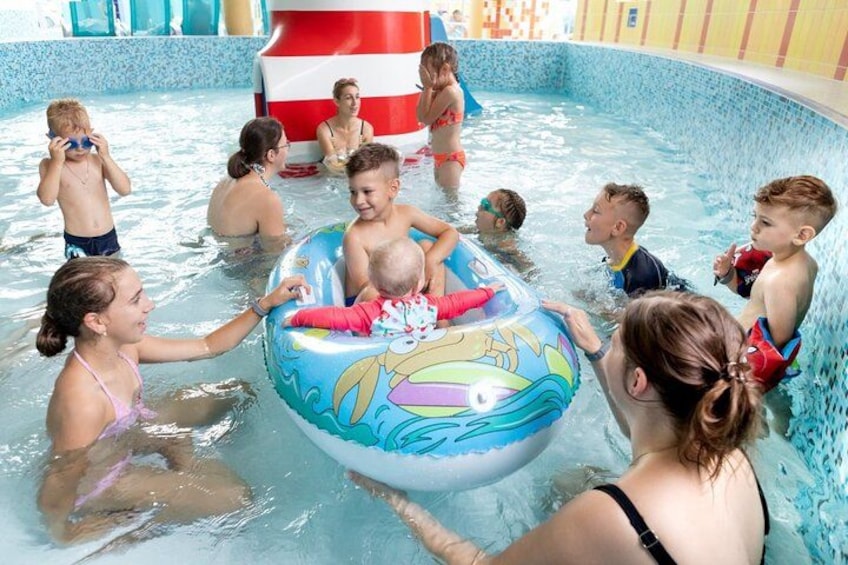 A swimming pool with inflatable toys and people swimming. 4