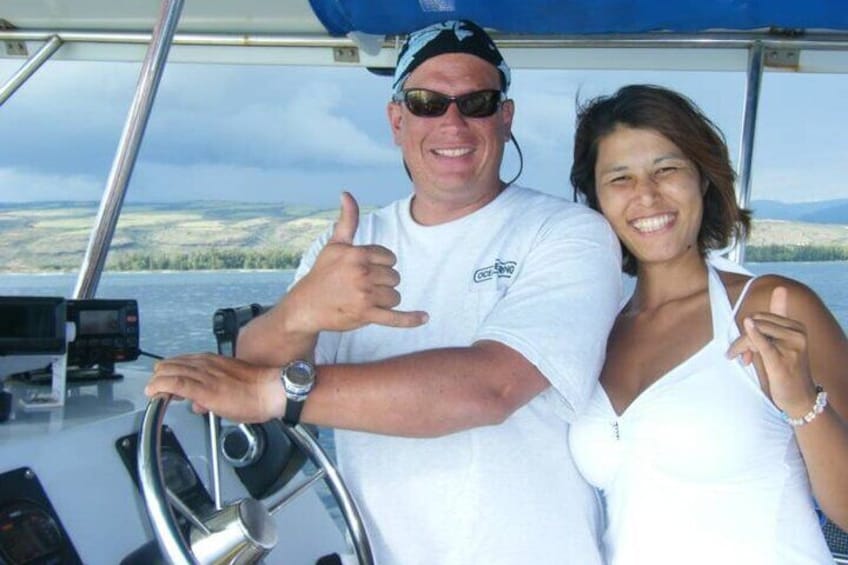 A person steering a boat with a scenic landscape in the background. 3