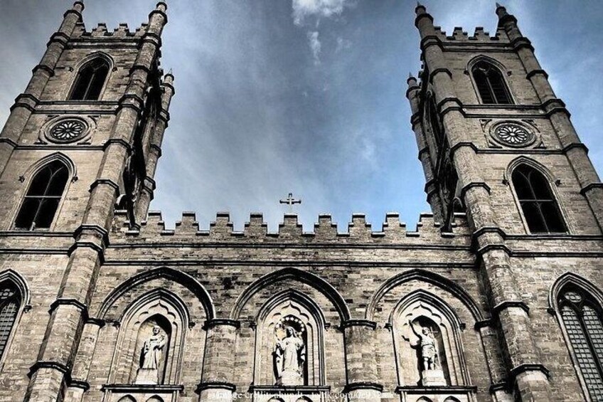 A historic church with two towers, arched windows, and statues. 5