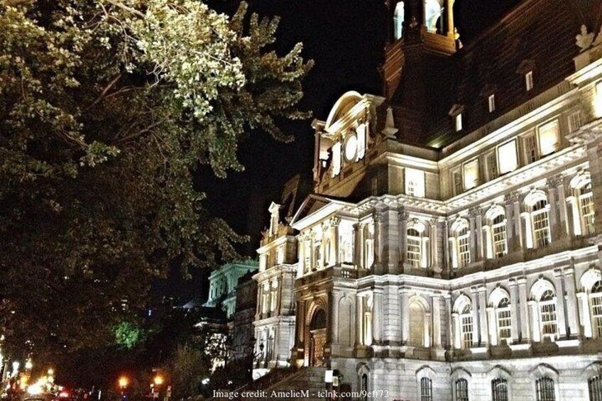 A historic building at night with illuminated windows and a clock tower. 3