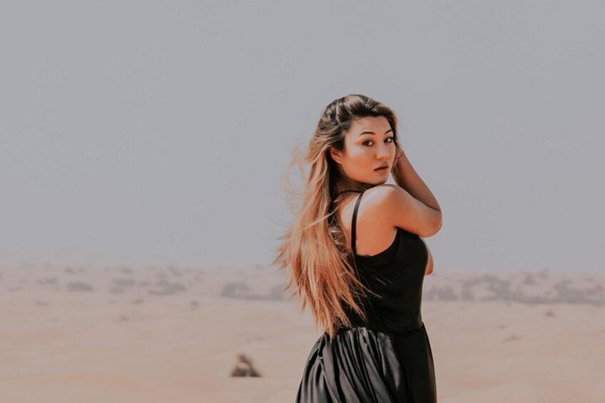 Una persona vestida de negro parada en un desierto con vegetación escasa. 2