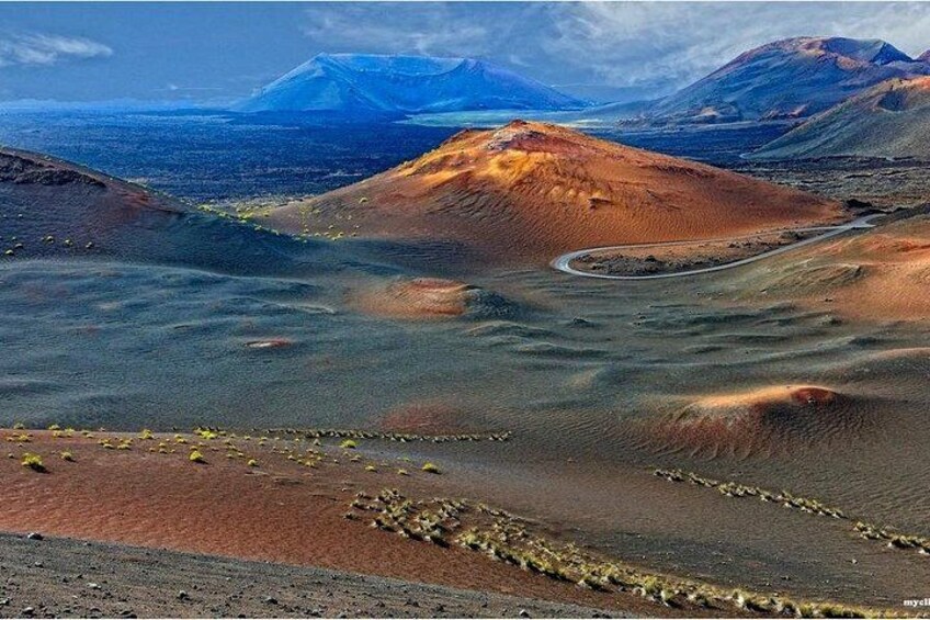 A vast desert landscape with rolling hills and a winding road. 2