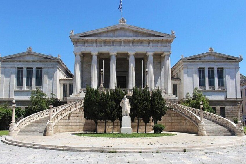 Un bâtiment de style néoclassique, orné de colonnes, d’une statue et d’un drapeau. 2