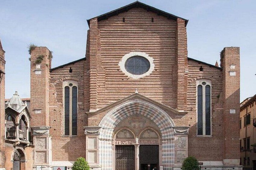 A historic church with a prominent arched entrance, a circular window, and a brick facade. 4