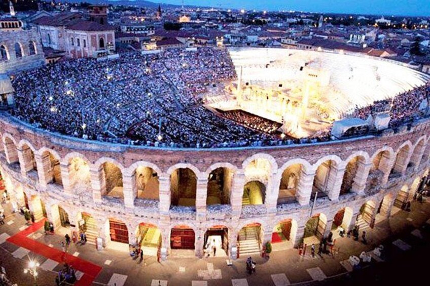 A large, historic amphitheater filled with spectators. 2