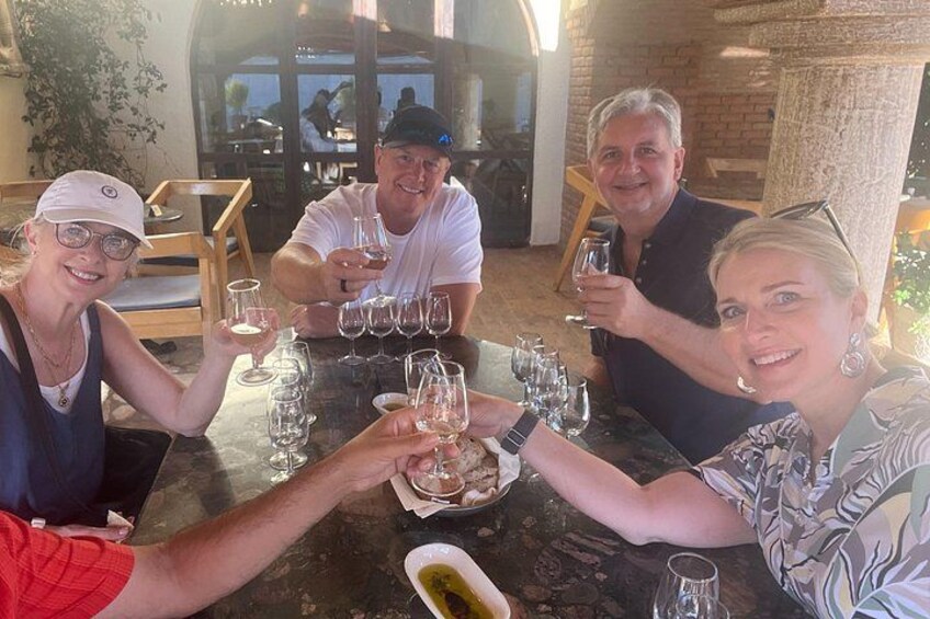 A group of people toasting with wine glasses at a table in a restaurant with a rustic interior. 2