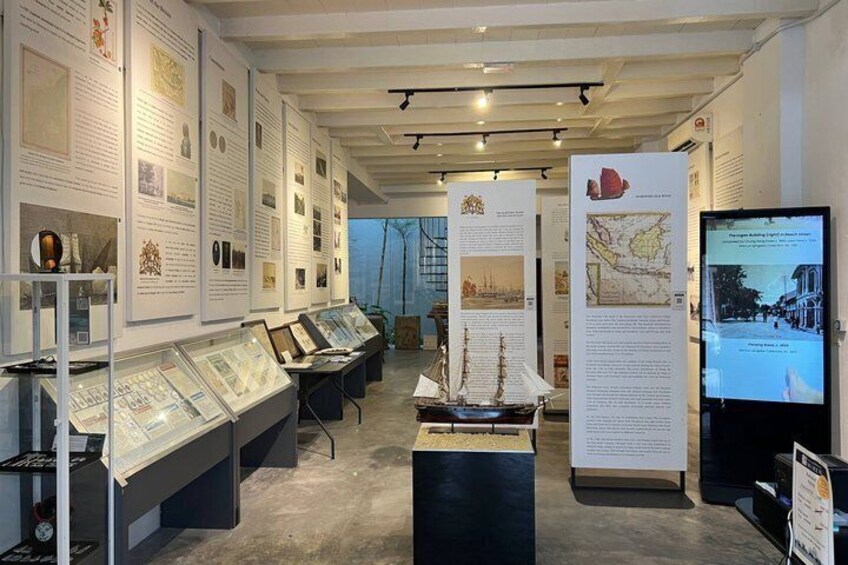Een overdekte tentoonstelling met vitrines, informatiepanelen en een digitaal scherm. 1
