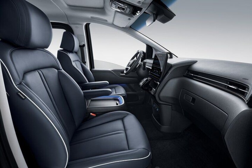 A car interior with black leather seats, a steering wheel, a dashboard, and a center console. 3