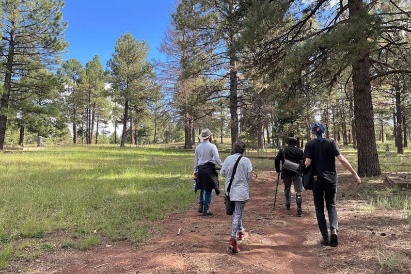 Un grupo de personas caminando por un sendero de tierra en un área boscosa. 4