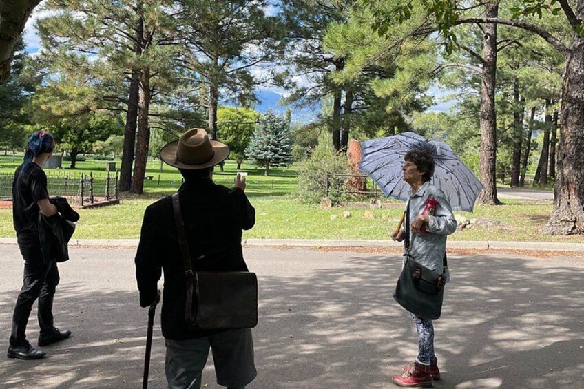 Una persona con sombrero y paraguas caminando por un sendero en un parque. 2