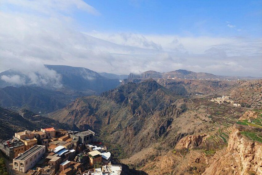 A mountainous landscape with a village nestled in a valley. 3