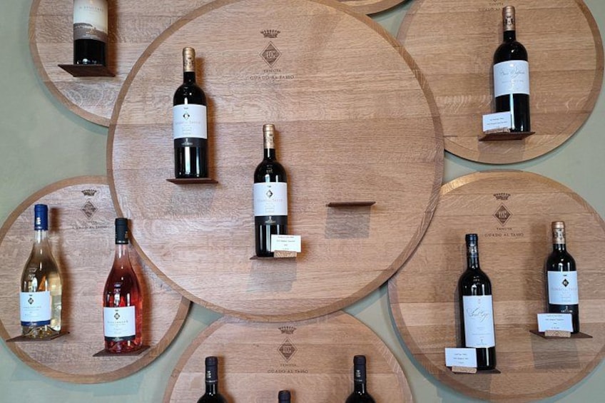 A collection of wine bottles displayed on wooden circular platforms. 2
