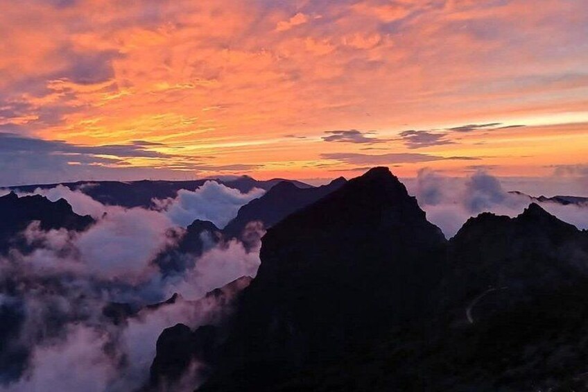 A mountain range with clouds at the base, under a sunset sky. 5