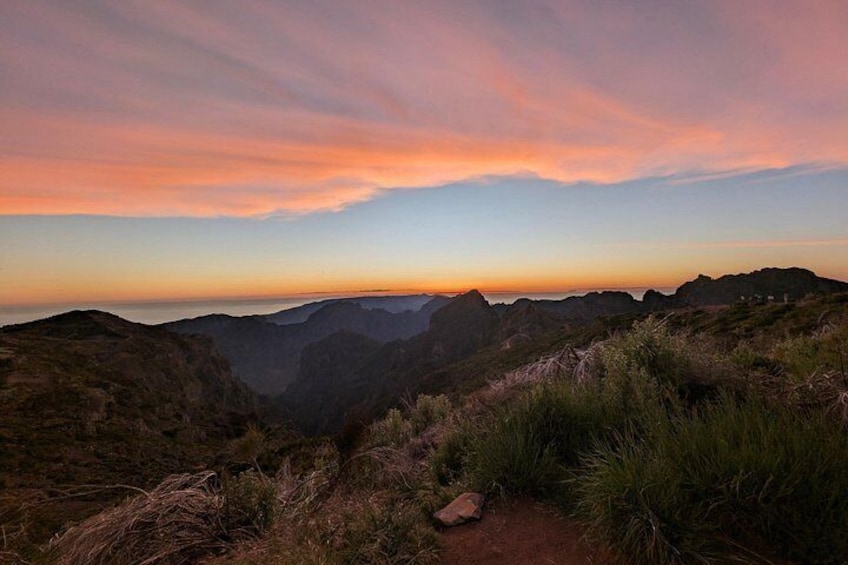 A mountainous landscape with a sunset sky. 1