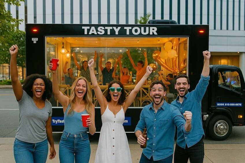 Un groupe de personnes fait la fête devant un camion-restaurant appelé « Tasty Tour ». 1