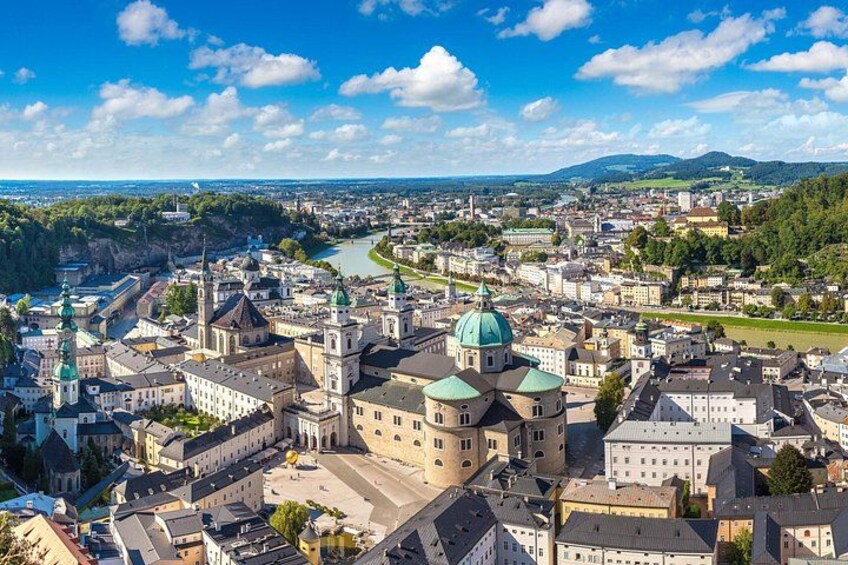 Et panorama over en by med en markant domkirke, en flod og frodigt grønt område omkring. 5