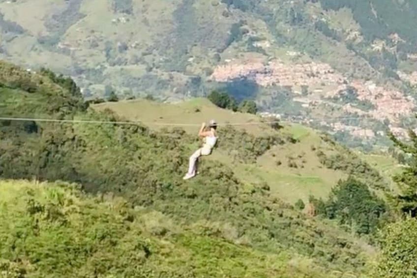 A person walking on a suspension bridge over a mountainous area. 1