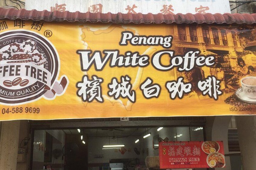Een etalage met een bord voor Penang White Coffee. 2