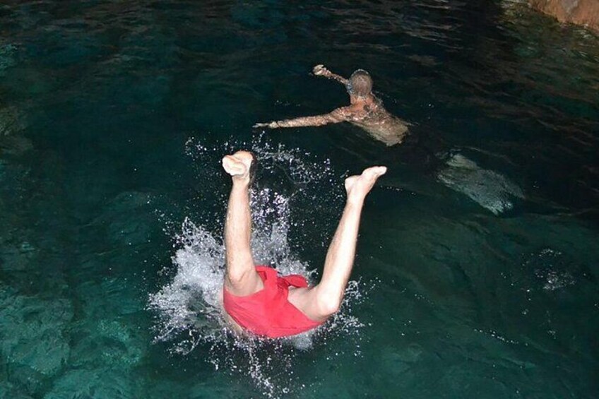 A person swimming in a pool with another person in the background. 5