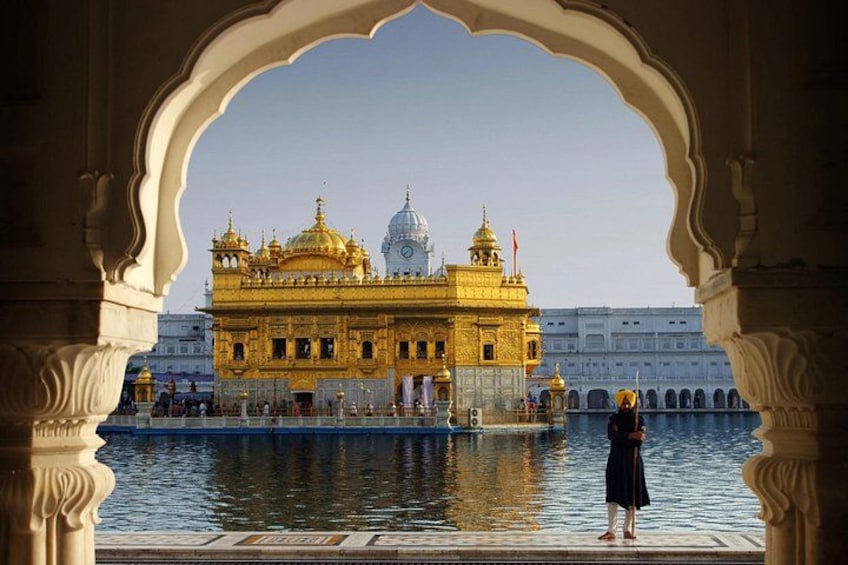 Un temple doré, orné de coupoles, qui se reflète dans l’eau, et un arc de triomphe. 1