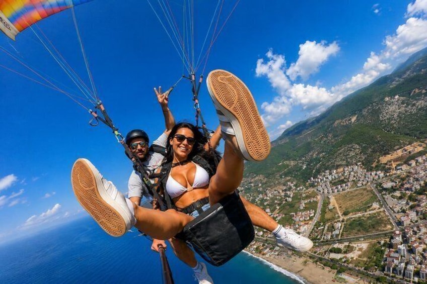 Eine Person gleitet mit einem Fallschirm über einer Stadtlandschaft und einer Küstenlinie. 4