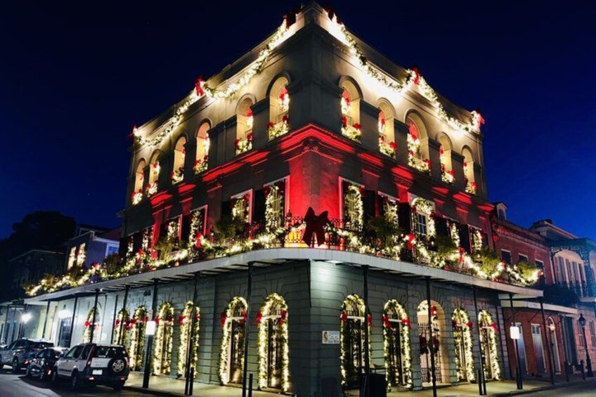 A building with arched windows and a balcony, decorated with lights and flowers. 4