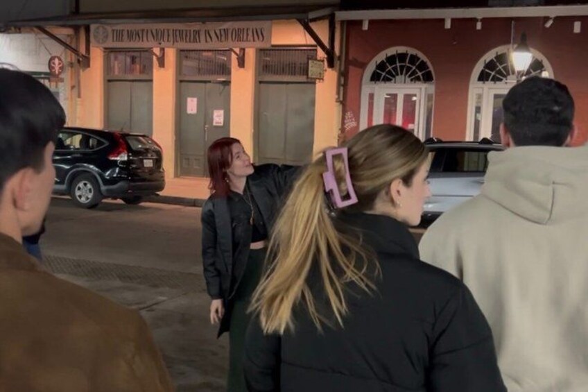 A group of people standing outside a jewelry store named 'The Most Unique Jewelry in New Orleans.' 3
