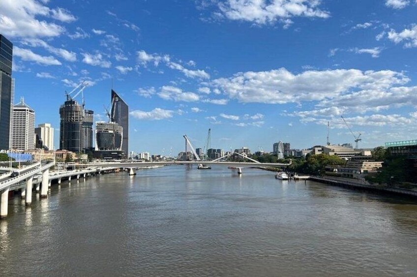 Une rivière traversée par un pont, des bâtiments modernes et un ciel dégagé. 2
