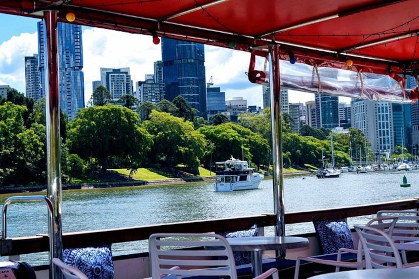 A river with a boat, city skyline, and green park areas. 3