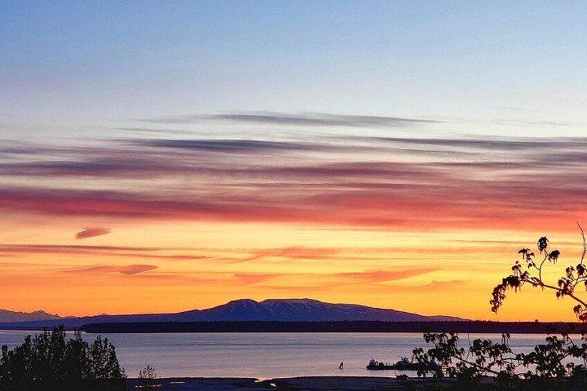 A sunset over a calm lake with mountains in the background. 2