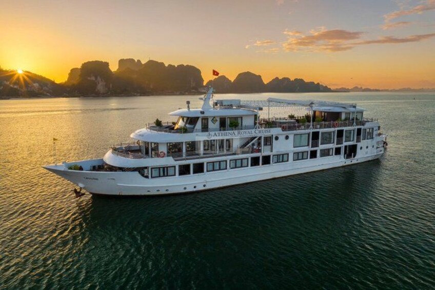 A large white river cruise ship with multiple decks and a flag, sailing on a calm river during sunset. 2